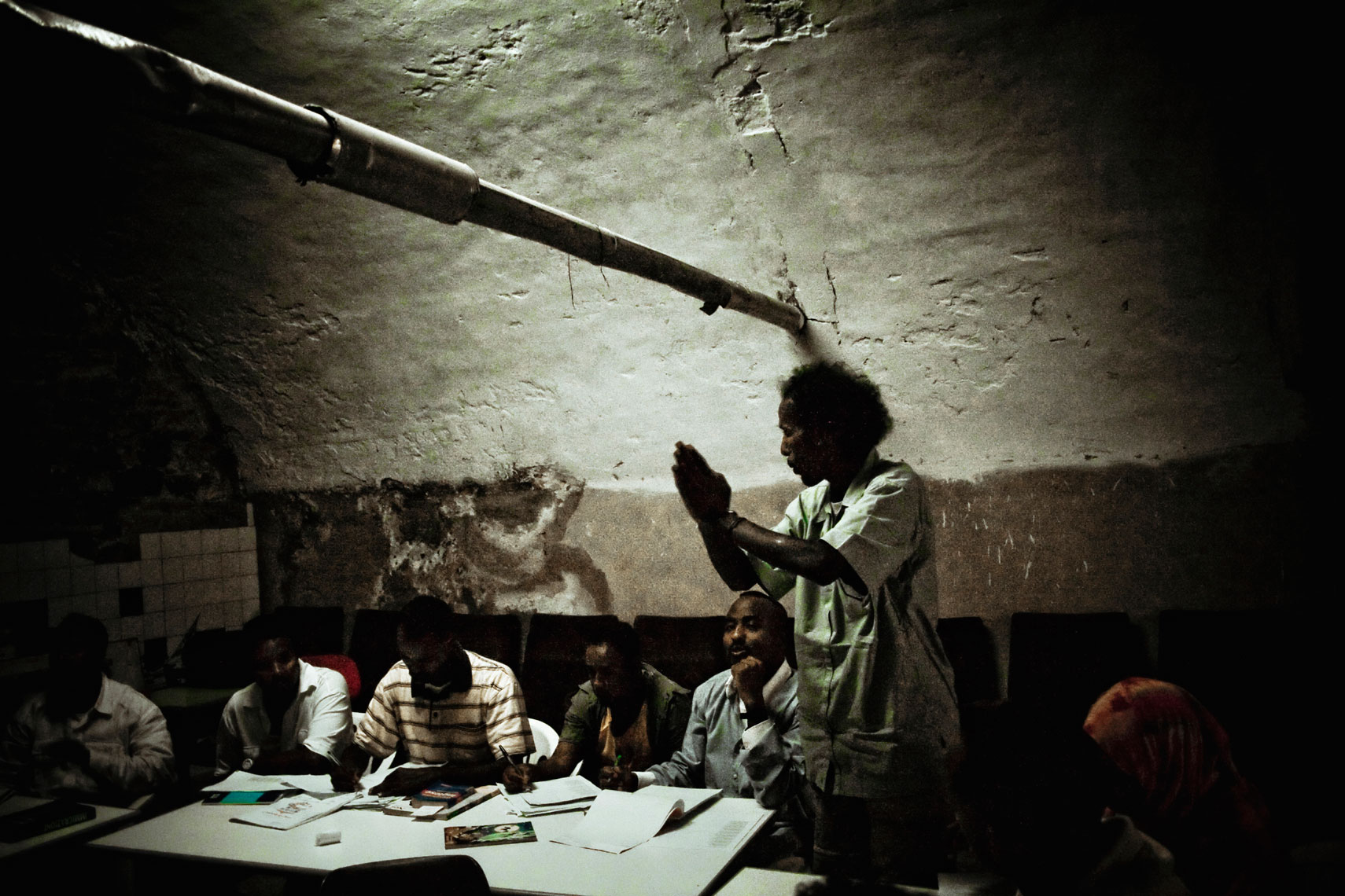 ITALY. Florence, 21st July 2009. Somali refugees attend to an Italian lessons run by some volunteers inside the "Kulanka" building. "Kulanka" (assembly in Somali language) is a former warehouse near the railways, occupied in 2008 by a group of Somali refugees together with an association that helps people without home, and gave,  in 2009 , for free temporary loan for use to an association of refugees, in according to a deal signed together with the city mayor.