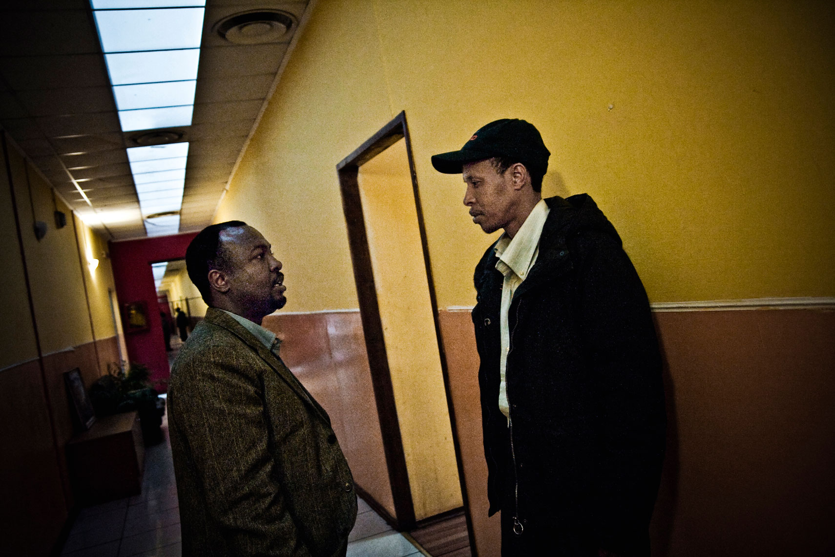 ITALY. Rome, 30th March 2011. Inside the "Baobab" welcome center. Amin, on the left, a refugee that helps other somali refugees to ask for papers and a place to live, talks to one host of the center.