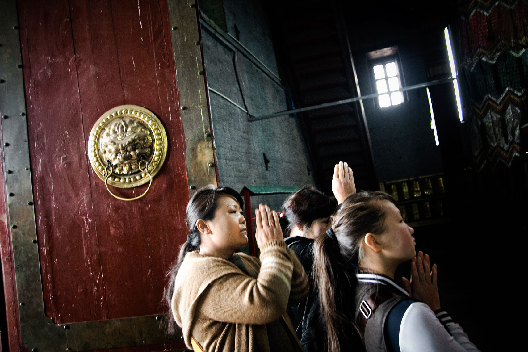 MONGOLIA. Ulan Bator, 2012. People pray inside the Boddhisattva Avalokiteshvara Temple in the Gandantegchinlen Monastery. The monastery is situated on a hill top near the Peace Avenue, city's main road.