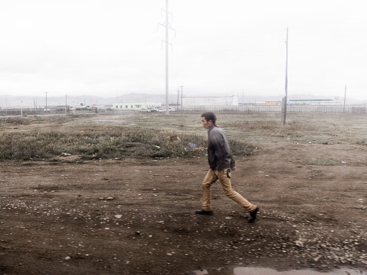 MONGOLIA. Ulan Bator, 2012. A man walking in the outskirts of the city. With a population of about 1,24 milion citizens Ulan Bator concentrate almost half the population of Mongolia. Resulting of the devastating winters of the past few years, known as Dzud, that killed thousands of animals, many families moved to the city. That new population, 60% of the city total, live in poor settlements inside the so called "Gher District" on the hills aroud the city.