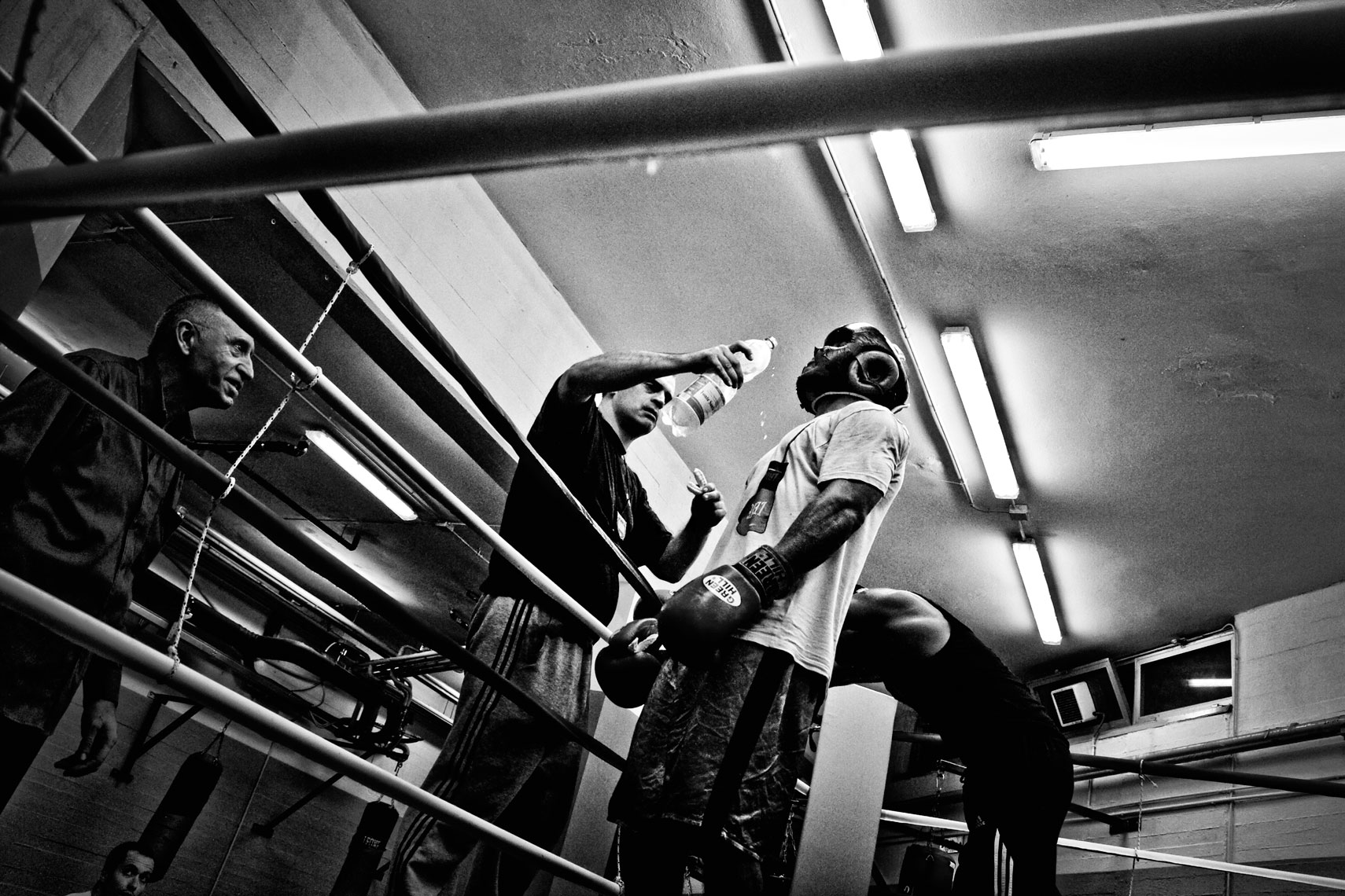ITALY. Florence, 6th October 2011. Leonard Bundu drinking some water by the help of his sparring partner trainer during the preparation of the match for the EBU (European Boxing Union) Welter Weight crown. On the left Bundu's master and trainer Alessandro Boncinelli.