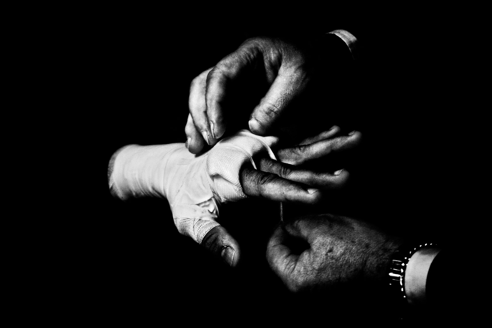 ITALY. Florence, 4th November 2011. Mandela Forum, the night of the match for the EBU (European Boxing Union) Welter Weight crown. Mr. Loreni, Leonard Bundu's agent, bandages athlete's hands.